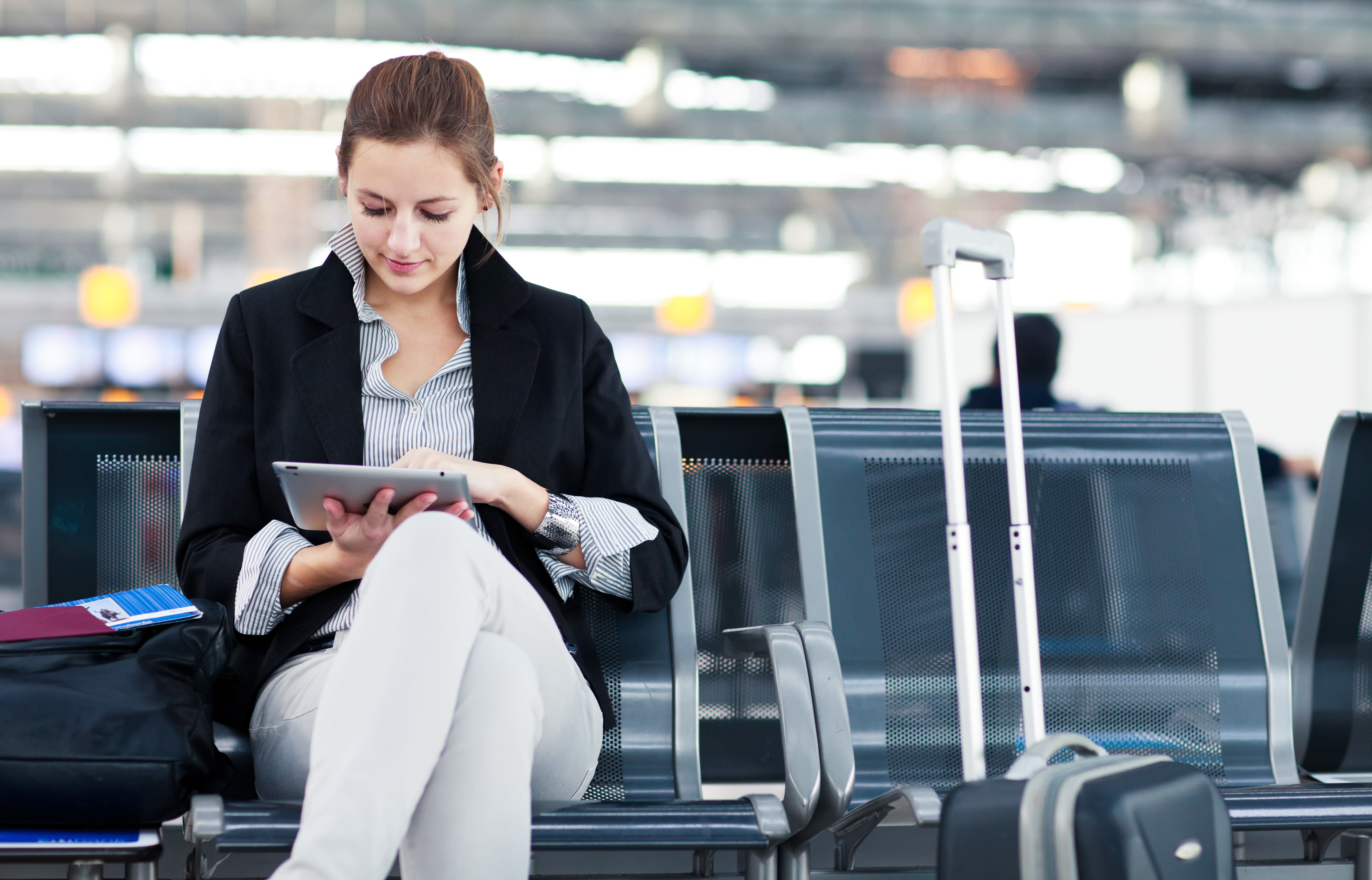 Woman at an airport using a tablet device